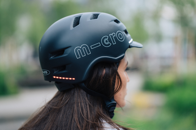 femme vu de profil portant un casque de protection avec lumière led rouge à l'arrière